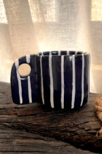 Tuxedo Stoneware Mug Quiet elegance, dressed in detail A glossy black stoneware mug with subtle tonal lines that add depth and structure, designed for a refined and timeless coffee moment.
