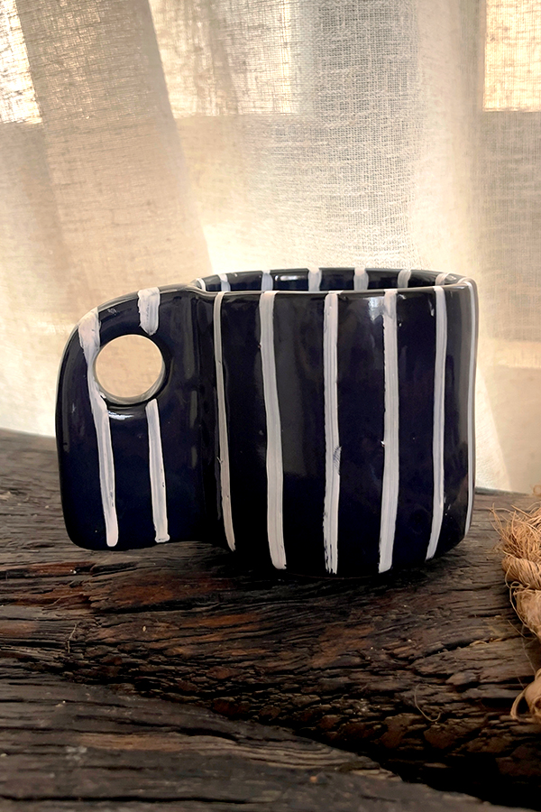 Tuxedo Stoneware Mug Quiet elegance, dressed in detail A glossy black stoneware mug with subtle tonal lines that add depth and structure, designed for a refined and timeless coffee moment.