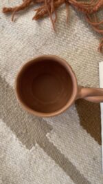 Doro Stoneware Mug Where craft becomes texture you can feel A light brown stoneware mug with a hammered texture inspired by traditional copper work, and a hand-braided handle that adds a unique artisanal character.