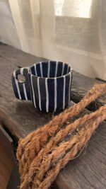 Tuxedo Stoneware Mug Quiet elegance, dressed in detail A glossy black stoneware mug with subtle tonal lines that add depth and structure, designed for a refined and timeless coffee moment.
