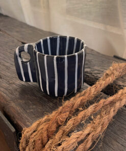 Tuxedo Stoneware Mug Quiet elegance, dressed in detail A glossy black stoneware mug with subtle tonal lines that add depth and structure, designed for a refined and timeless coffee moment.