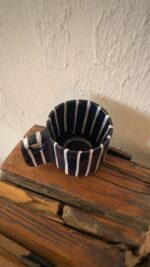Tuxedo Stoneware Mug Quiet elegance, dressed in detail A glossy black stoneware mug with subtle tonal lines that add depth and structure, designed for a refined and timeless coffee moment.