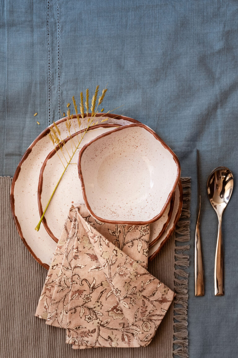 Rhea Angle Dinnerware SET Earth tones for grounded, beautiful tables A handcrafted stoneware dinnerware set in soft beige tones with subtle brown speckles and hand-finished brown edges, designed for warm and natural dining experiences.
