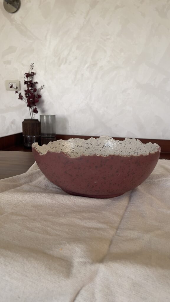 An extra-large stoneware serve bowl with a beautiful cream color and natural dark speckles. It features unique, rough edges for a natural look. With its huge size, it is perfect for serving big family salads, fruits, or hosting guests.
