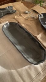 Mori Sharing Platter Captivating with its rich burgundy glaze and gently scalloped rim, this expansive stoneware platter brings a touch of dramatic warmth to your table. Its low, sleek profile makes it an exquisite backdrop for artistic food presentation or a striking accent piece for grand hosting.