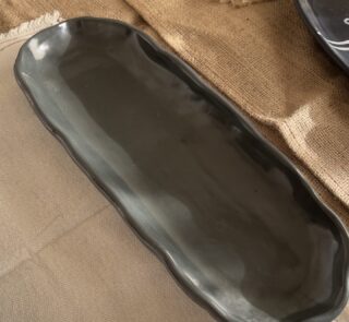 Mori Sharing Platter Captivating with its rich burgundy glaze and gently scalloped rim, this expansive stoneware platter brings a touch of dramatic warmth to your table. Its low, sleek profile makes it an exquisite backdrop for artistic food presentation or a striking accent piece for grand hosting.