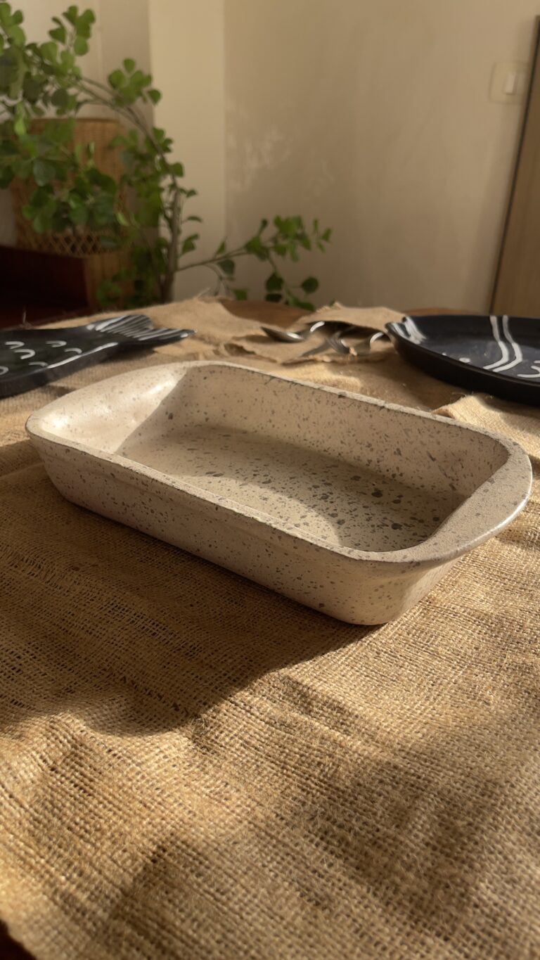 Pebble Oven Dish A beautiful rectangular stoneware dish with a warm sandy color and natural dark speckles. Perfect for both baking in the oven and serving directly on the table. It is great for making family meals, pasta, or roasted dishes.