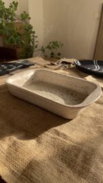 Pebble Oven Dish A beautiful rectangular stoneware dish with a warm sandy color and natural dark speckles. Perfect for both baking in the oven and serving directly on the table. It is great for making family meals, pasta, or roasted dishes.