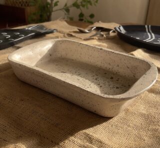 Pebble Oven Dish A beautiful rectangular stoneware dish with a warm sandy color and natural dark speckles. Perfect for both baking in the oven and serving directly on the table. It is great for making family meals, pasta, or roasted dishes.