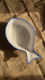 Caspian Fish Bowl Enjoy your seafood in a refreshing, open-air seaside vibe. Featuring a clean white base and a vibrant blue hand-painted rim, this fish-shaped individual bowl is perfect for your personal servings of seafood soup or pasta.