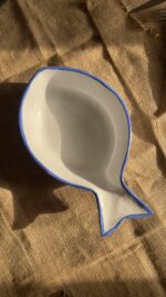 Caspian Fish Bowl Enjoy your seafood in a refreshing, open-air seaside vibe. Featuring a clean white base and a vibrant blue hand-painted rim, this fish-shaped individual bowl is perfect for your personal servings of seafood soup or pasta.