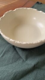 Ivory Serve Bowl A beautiful stoneware serve bowl with a soft creamy white color. It features unique, rough edges for a natural touch. With its perfect size, it is great for serving salads, hot soups, or daily dishes.