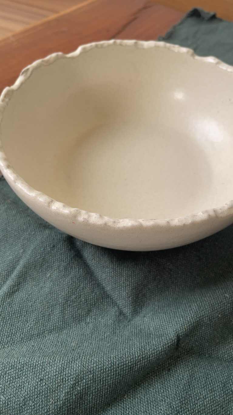 Ivory Serve Bowl A beautiful stoneware serve bowl with a soft creamy white color. It features unique, rough edges for a natural touch. With its perfect size, it is great for serving salads, hot soups, or daily dishes.