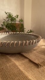 Crafted from a unique mix of natural bamboo and durable stoneware, this eye-catching serving platter stands out with its artfully detailed stitched borders. Ideal for both styling your home and serving snacks, it seamlessly adds an authentic, earthy vibe to your space.