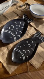 Ocean Fish Dinnerware Set A unique fish-shaped stoneware dinnerware collection in a rich dark blue color with charming hand-painted white details. It adds a modern, sea-inspired touch to your dining table.