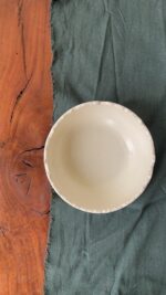 Ivory Serve Bowl A beautiful stoneware serve bowl with a soft creamy white color. It features unique, rough edges for a natural touch. With its perfect size, it is great for serving salads, hot soups, or daily dishes.