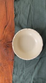 Ivory Serve Bowl A beautiful stoneware serve bowl with a soft creamy white color. It features unique, rough edges for a natural touch. With its perfect size, it is great for serving salads, hot soups, or daily dishes.