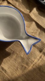Caspian Fish Bowl Enjoy your seafood in a refreshing, open-air seaside vibe. Featuring a clean white base and a vibrant blue hand-painted rim, this fish-shaped individual bowl is perfect for your personal servings of seafood soup or pasta.