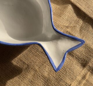 Caspian Fish Bowl Enjoy your seafood in a refreshing, open-air seaside vibe. Featuring a clean white base and a vibrant blue hand-painted rim, this fish-shaped individual bowl is perfect for your personal servings of seafood soup or pasta.