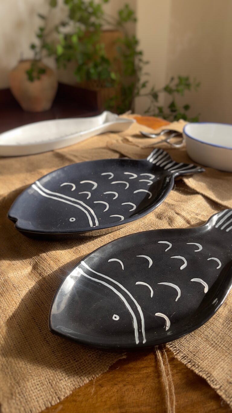 Ocean Fish Dinnerware Set A unique fish-shaped stoneware dinnerware collection in a rich dark blue color with charming hand-painted white details. It adds a modern, sea-inspired touch to your dining table.