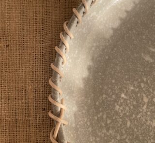 Crafted from a unique mix of natural bamboo and durable stoneware, this eye-catching serving platter stands out with its artfully detailed stitched borders. Ideal for both styling your home and serving snacks, it seamlessly adds an authentic, earthy vibe to your space.