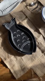 Ocean Fish Dinnerware Set A unique fish-shaped stoneware dinnerware collection in a rich dark blue color with charming hand-painted white details. It adds a modern, sea-inspired touch to your dining table.