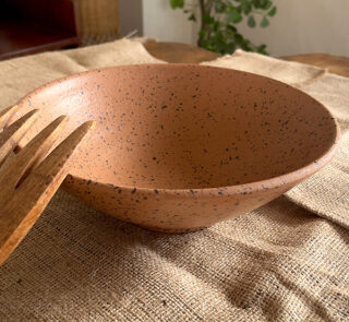 Conical Serve Bowl A large and beautiful stoneware serve bowl with a warm sandy color and natural dark speckles. With its wide shape, it is perfect for serving big family salads, fruits, or main dishes.