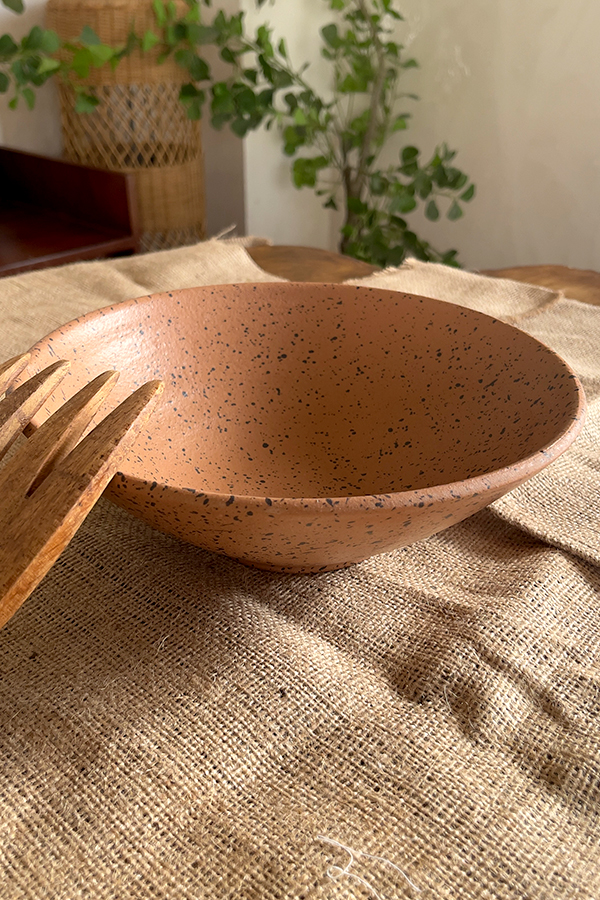 Conical Serve Bowl A large and beautiful stoneware serve bowl with a warm sandy color and natural dark speckles. With its wide shape, it is perfect for serving big family salads, fruits, or main dishes.