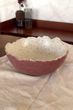 An extra-large stoneware serve bowl with a beautiful cream color and natural dark speckles. It features unique, rough edges for a natural look. With its huge size, it is perfect for serving big family salads, fruits, or hosting guests.