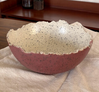 An extra-large stoneware serve bowl with a beautiful cream color and natural dark speckles. It features unique, rough edges for a natural look. With its huge size, it is perfect for serving big family salads, fruits, or hosting guests.