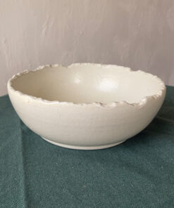 Ivory Serve Bowl A beautiful stoneware serve bowl with a soft creamy white color. It features unique, rough edges for a natural touch. With its perfect size, it is great for serving salads, hot soups, or daily dishes.