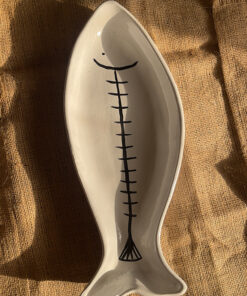 Azura Serving Platter Crafted from durable stoneware, this beautiful fish-shaped serving platter stands out with its clean white glaze and artistic hand-painted black fishbone design. It is perfect for adding a stylish sea-inspired vibe to any meal.