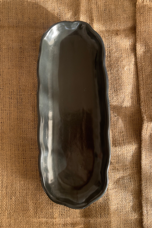 Mori Sharing Platter Captivating with its rich burgundy glaze and gently scalloped rim, this expansive stoneware platter brings a touch of dramatic warmth to your table. Its low, sleek profile makes it an exquisite backdrop for artistic food presentation or a striking accent piece for grand hosting.