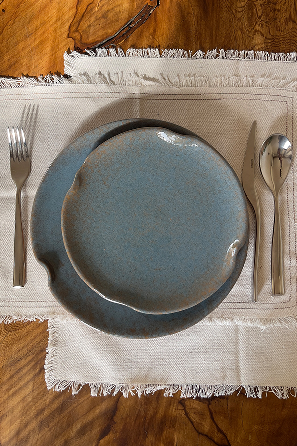 Remnant Dinnerware Plate Inspired by the quiet traces of nature, this organic stoneware plate features unique speckled textures and artfully distorted rims. The calming harmony of sky blue and rock grey makes the Remnant set less of a dinnerware and more of a sculpted art piece for your dining space.