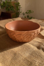 Canyon Serve Bowl A unique stoneware bowl with a beautiful carved design on the outside. It comes in a warm, natural brown clay color. With its deep shape, it is perfect for serving salads, fruits, or hot dishes.