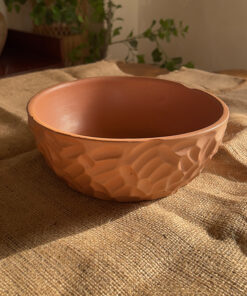 Canyon Serve Bowl A unique stoneware bowl with a beautiful carved design on the outside. It comes in a warm, natural brown clay color. With its deep shape, it is perfect for serving salads, fruits, or hot dishes.