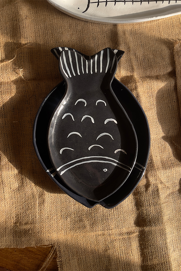 Ocean Fish Dinnerware Set A unique fish-shaped stoneware dinnerware collection in a rich dark blue color with charming hand-painted white details. It adds a modern, sea-inspired touch to your dining table.